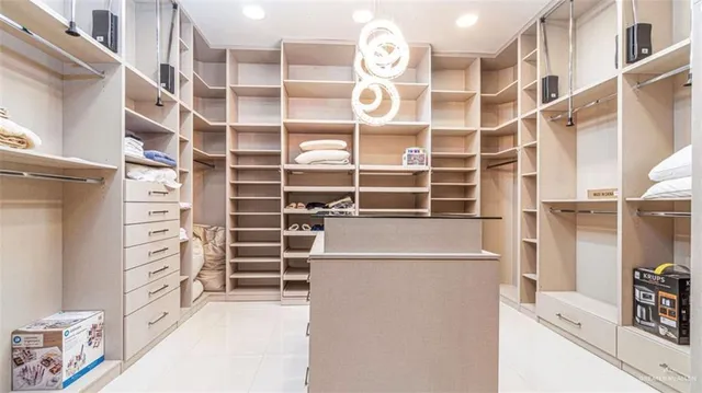 a view of walk in closet with clothes and shoes