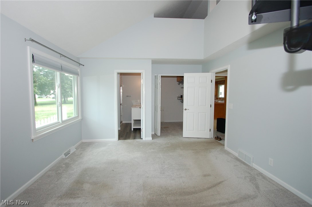 1299 State Road Vermilion, OH 44089 - Photo 21 of 36 Master bedroom featuring carpet floors, ensuite bath, and high vaulted ceiling