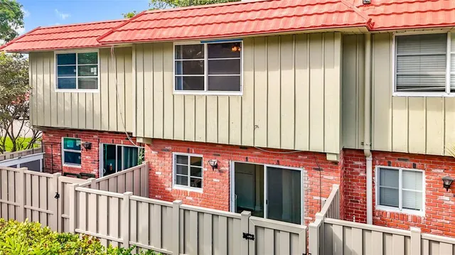 a view of a house with a small yard and wooden floor and fence