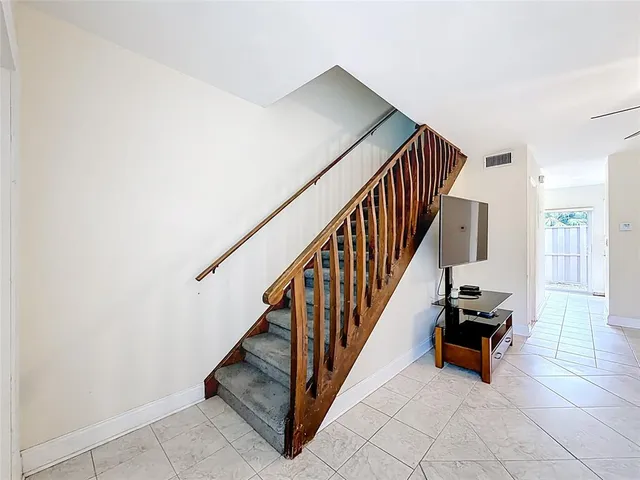 a view of staircase with railing and a potted plant