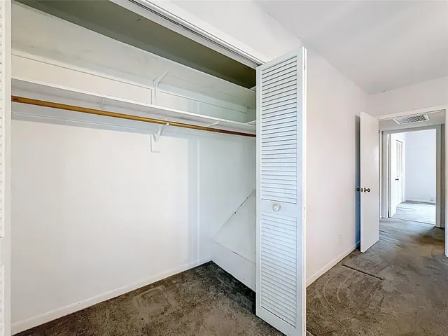 an empty room with fan and windows