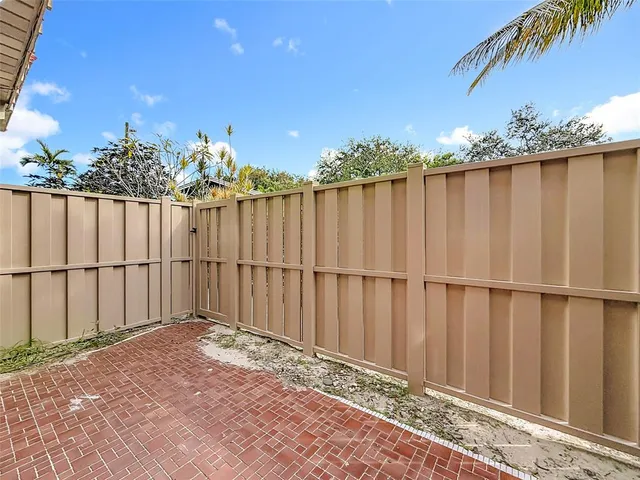 a view of a brick house with wooden fence