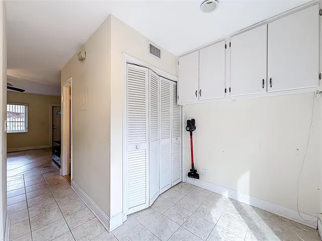 an empty room with windows and fan