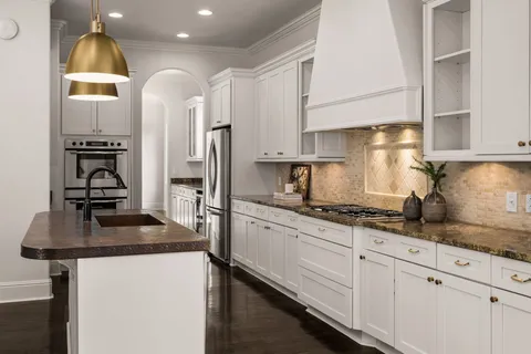 a kitchen with granite countertop a sink stainless steel appliances and cabinets