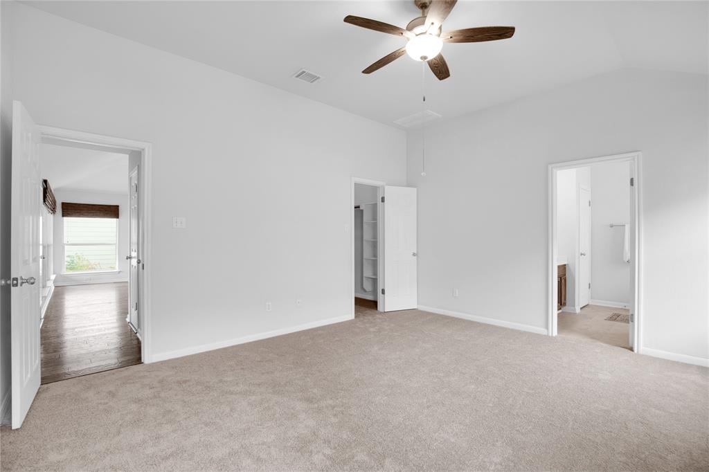 281 Hutton Kyle, TX 78640 - Photo 22 of 37 A spacious bedroom offers comfort, featuring a ceiling fan and plush carpet.