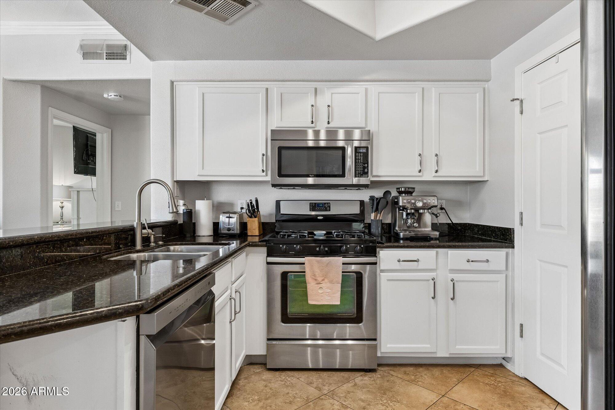 a kitchen with granite countertop a sink and cabinets
