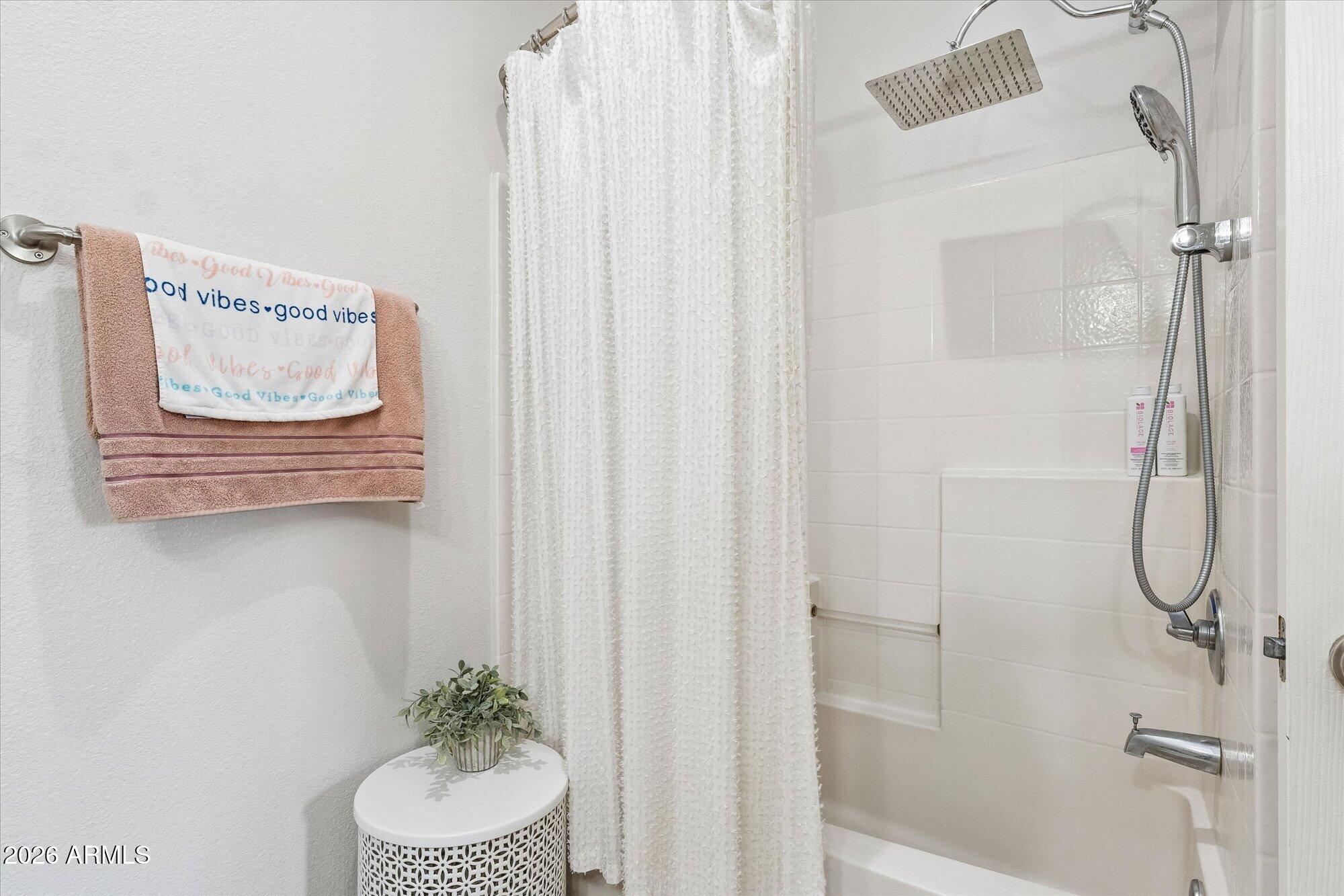 10030 West Indian School Road, Unit 269 Phoenix, AZ 85037 - Photo 13 of 29 a bathroom with a shower curtain and a window