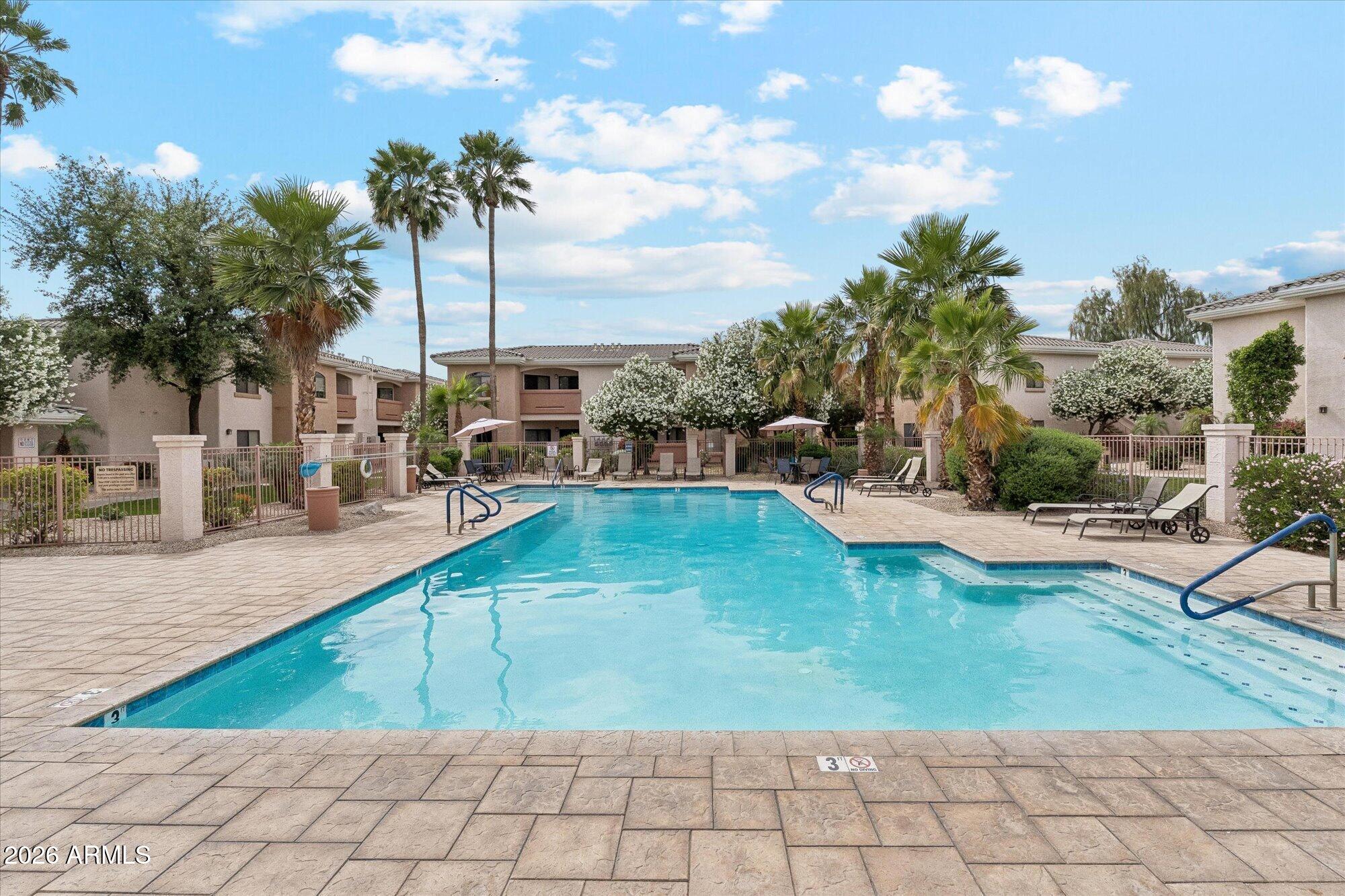 10030 West Indian School Road, Unit 269 Phoenix, AZ 85037 - Photo 21 of 29 a swimming pool with outdoor seating and yard