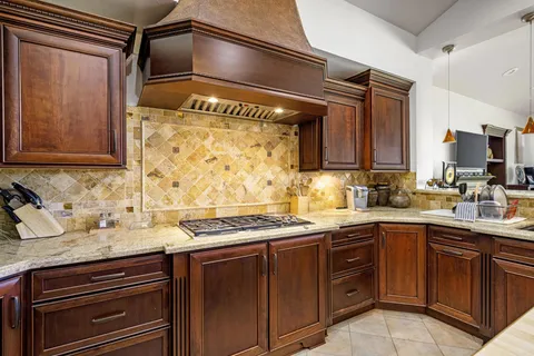 a kitchen with stainless steel appliances kitchen island granite countertop a sink and wooden cabinets