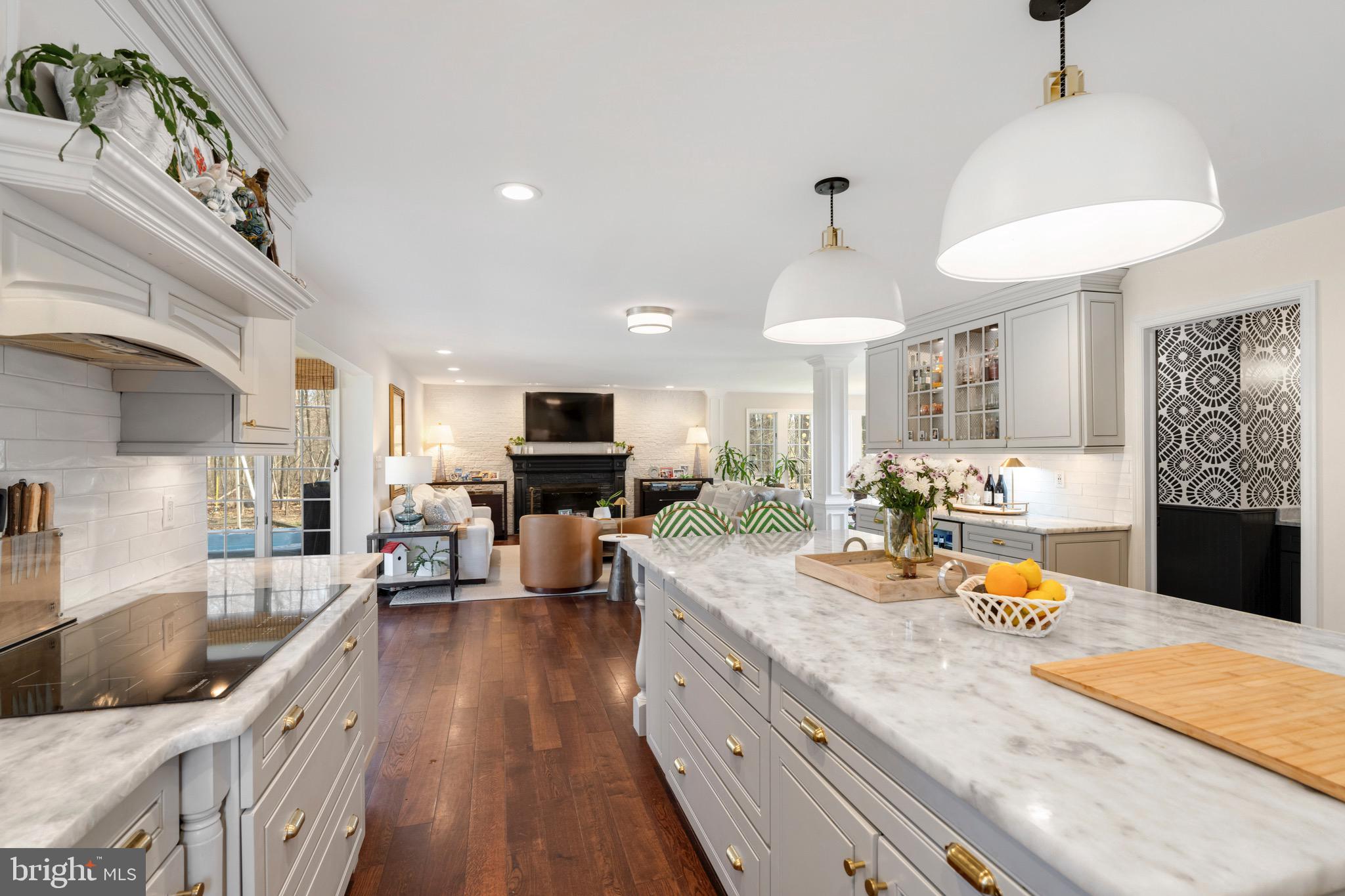 3618 Jackson Cabin Road Phoenix, MD 21131 - Photo 13 of 68 a large kitchen with stainless steel appliances kitchen island granite countertop a sink dishwasher and a fireplace with wooden floor