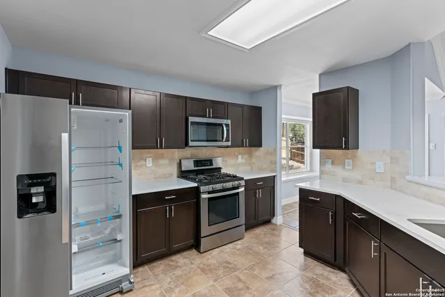 a kitchen with stainless steel appliances granite countertop a refrigerator stove and sink