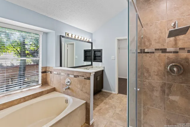 a bathroom with a tub sink and mirror
