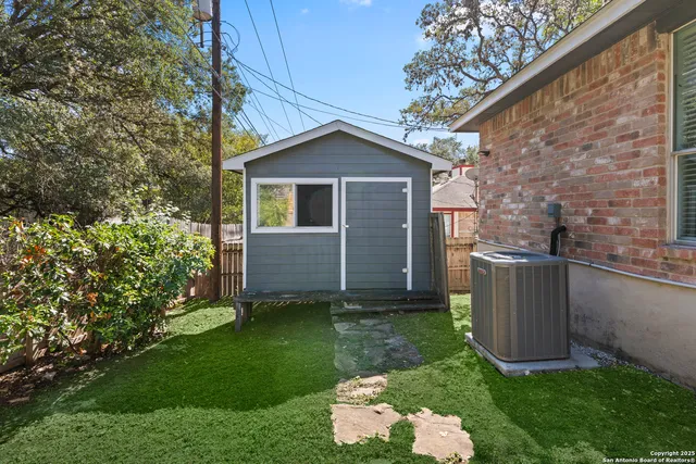 a view of backyard with a barn and a large tree