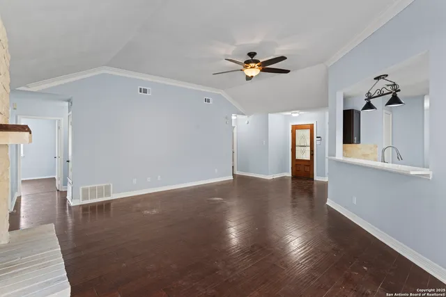 a view of a livingroom with wooden floor and a ceiling fan