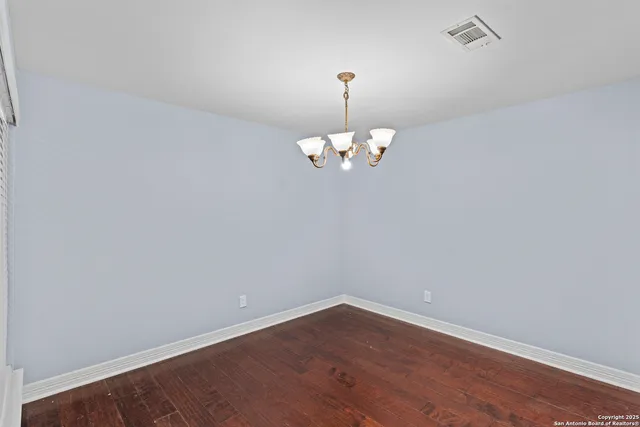 a view of a room with wooden floor and chandelier