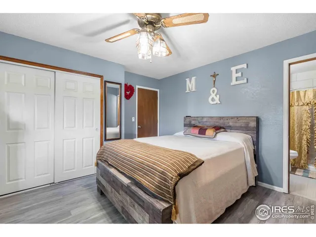 a bedroom with a large bed a chandelier and a window