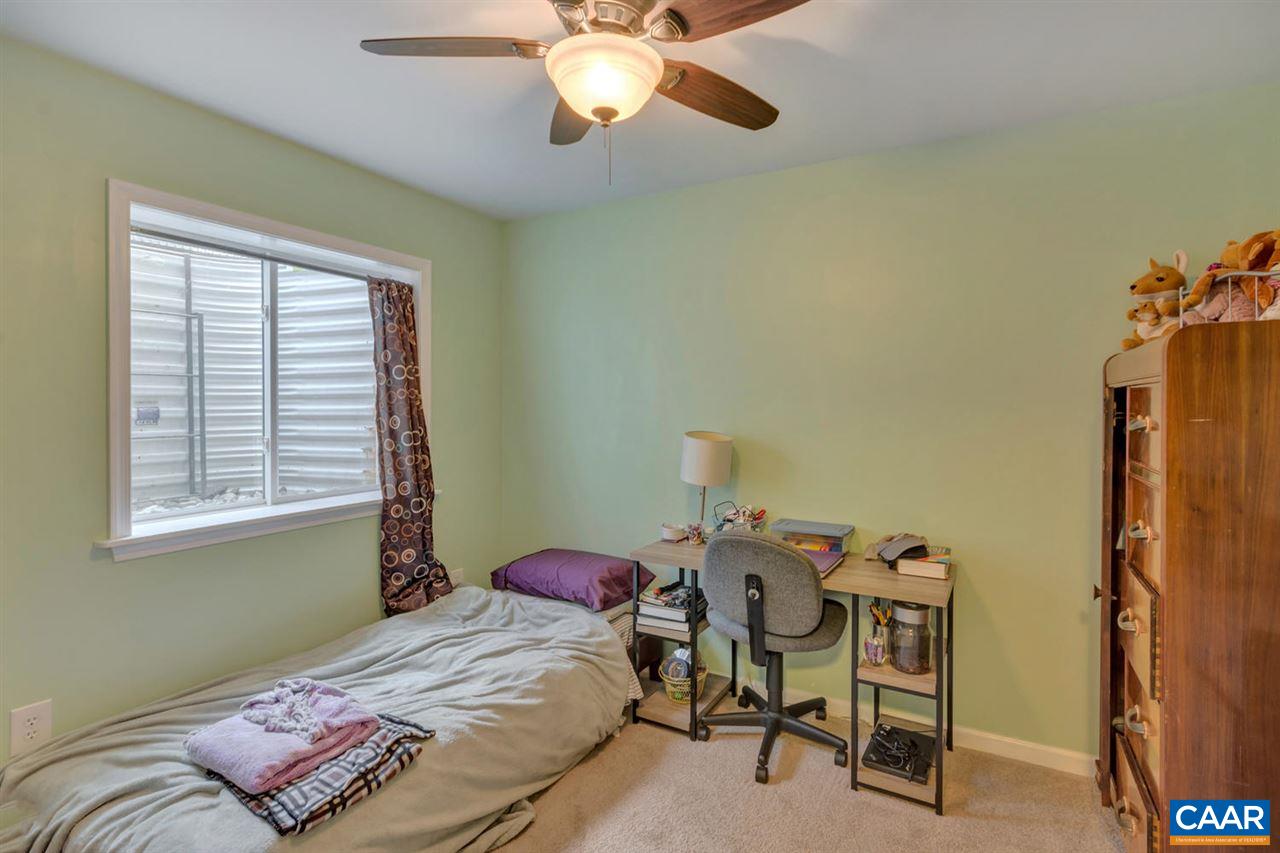 474 Rolkin Road Charlottesville, VA 22911 - Photo 21 of 42 a bedroom with a bed and a chandelier