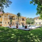 a front view of a house with a garden and trees