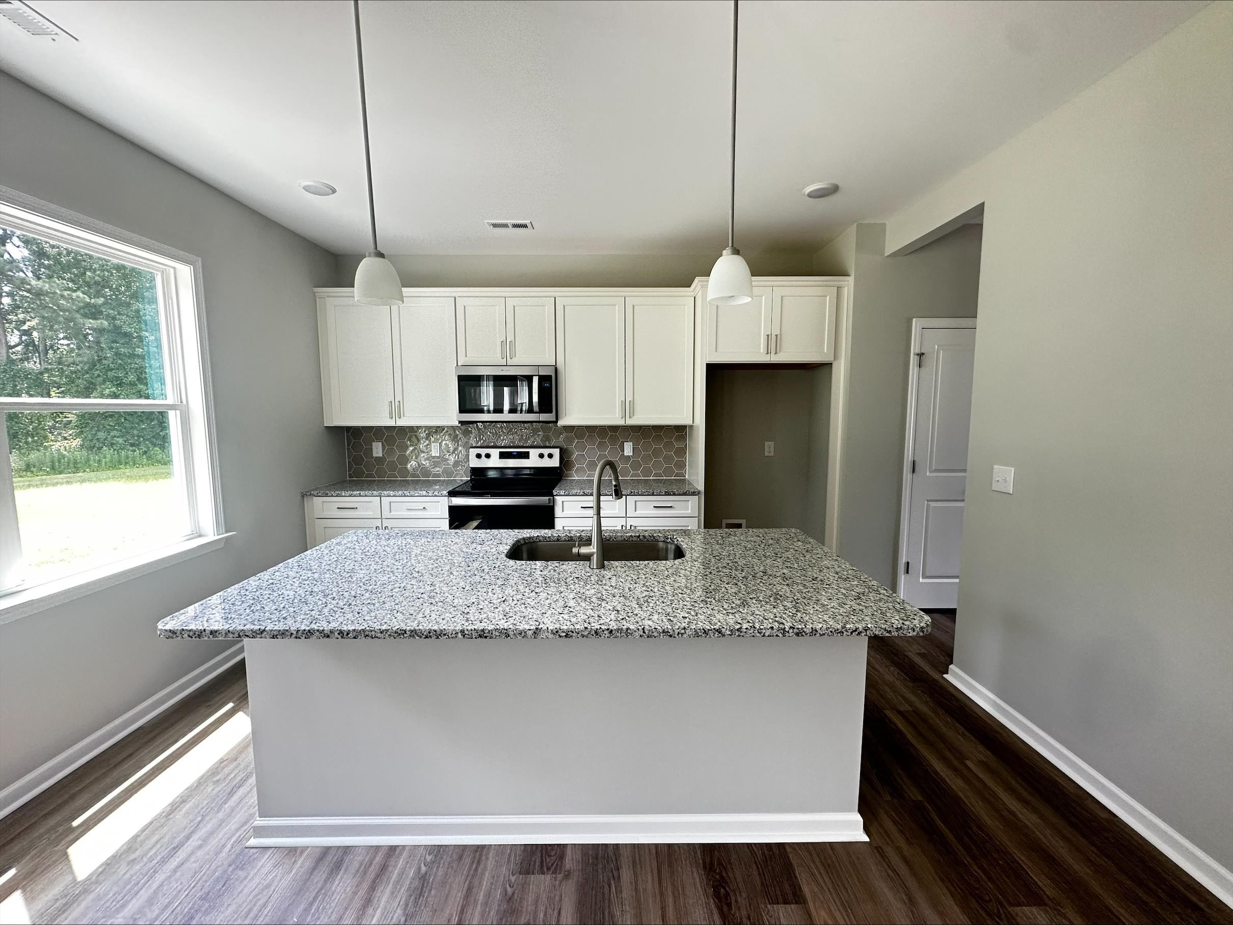 40 Daffodil Garden Smithfield, NC 27577 - Photo 4 of 17 a kitchen with kitchen island a counter space a sink appliances and cabinets