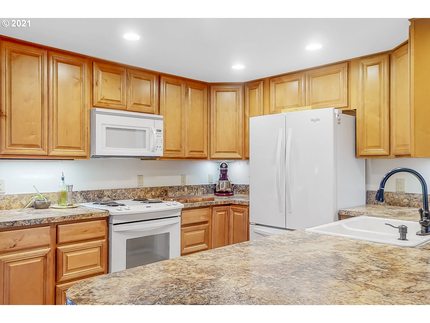 2486 York Street Eugene, OR 97404 - Photo 11 of 31 a kitchen with stainless steel appliances granite countertop a stove a refrigerator a sink dishwasher and wooden cabinets with a large window