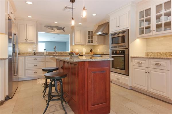 21 Elmwood Road Wellesley, MA 02481 - Photo 3 of 27 a kitchen with stainless steel appliances kitchen island granite countertop a table chairs sink and cabinets