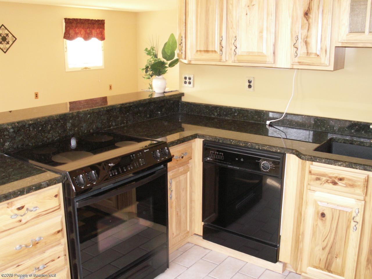 0 Rr 1 Meshoppen, PA 18630 - Photo 13 of 25 a kitchen with granite countertop a stove top oven and cabinets