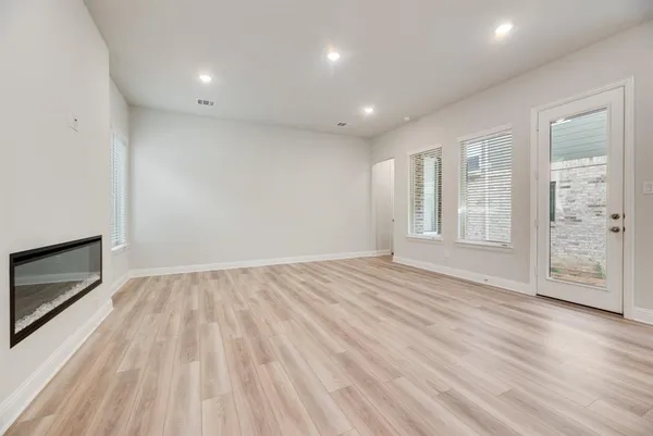a view of an empty room with a fireplace and a window