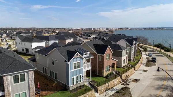an aerial view of a house with a yard and lake view
