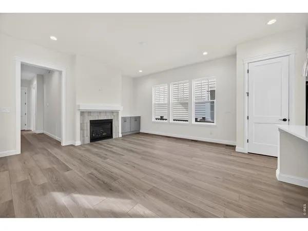 an empty room with wooden floor and fireplace