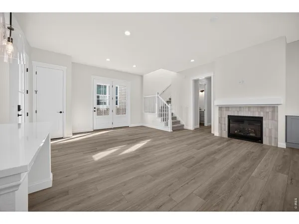 a view of empty room with wooden floor and fireplace