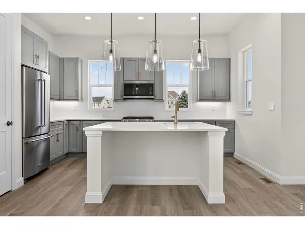 a kitchen with kitchen island a sink appliances and cabinets