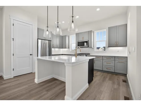 a kitchen with kitchen island white cabinets and stainless steel appliances
