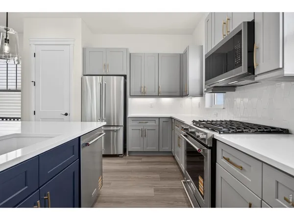 a kitchen with stainless steel appliances a stove microwave and refrigerator