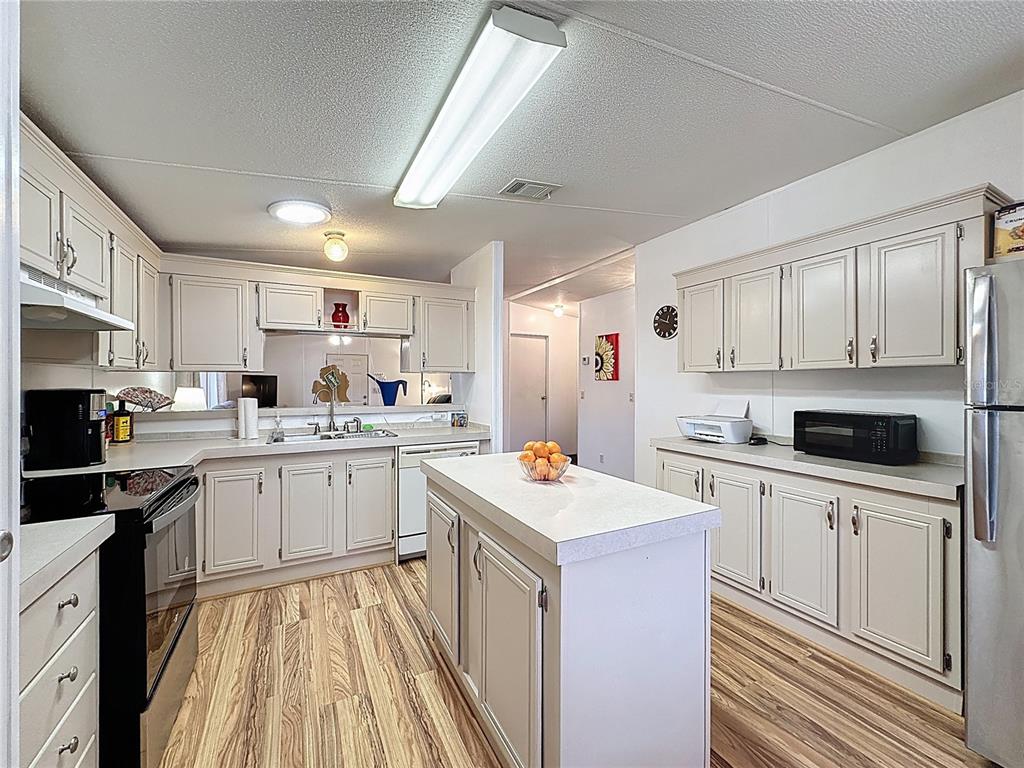251 Patterson Road, Unit I3 Haines City, FL 33844 - Photo 11 of 38 a kitchen with a sink a stove top oven and white cabinets