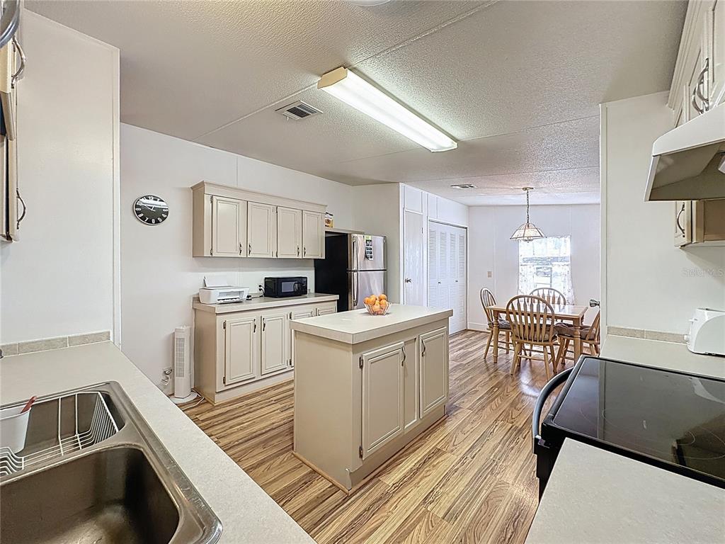 251 Patterson Road, Unit I3 Haines City, FL 33844 - Photo 12 of 38 a kitchen with a sink stove and white cabinets