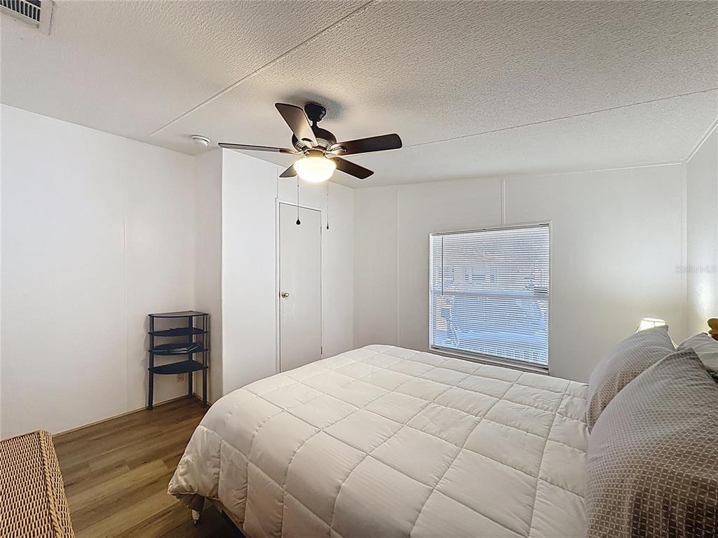 251 Patterson Road, Unit I3 Haines City, FL 33844 - Photo 20 of 38 a bedroom with a bed and a chandelier