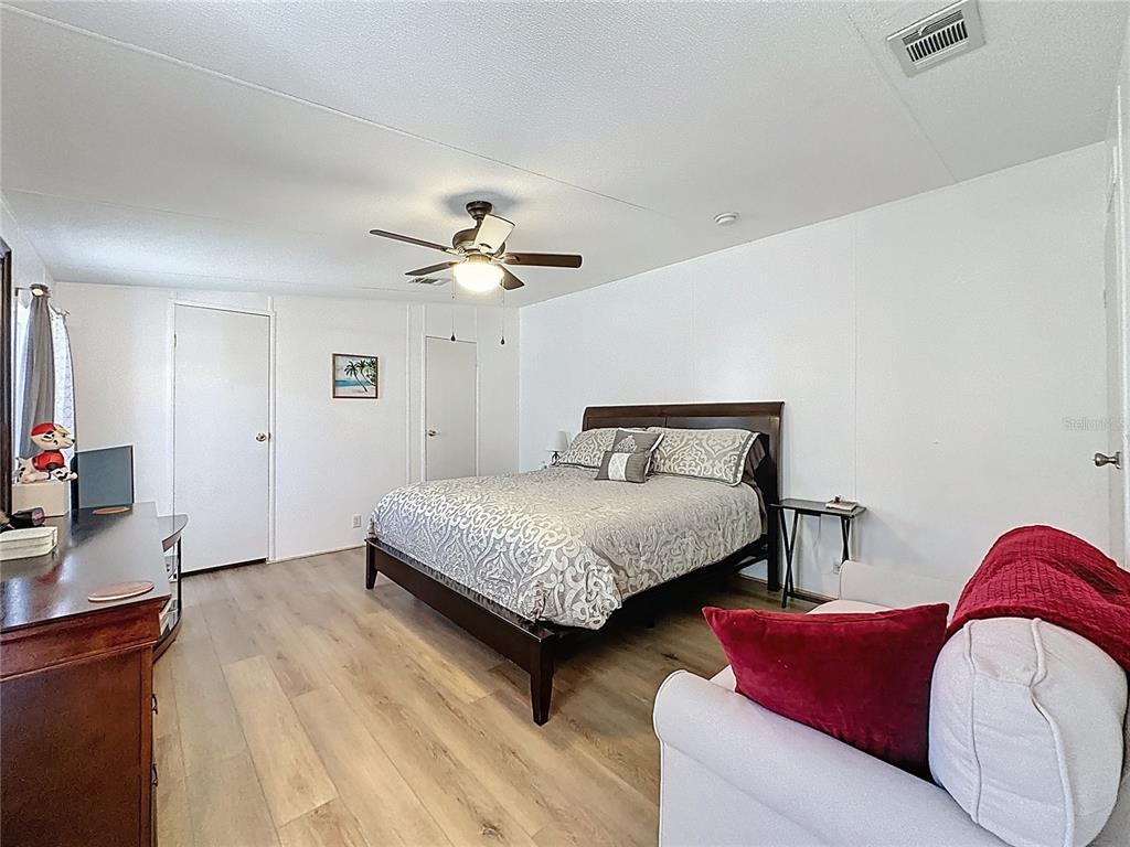 251 Patterson Road, Unit I3 Haines City, FL 33844 - Photo 23 of 38 a bedroom with bed and a chandelier