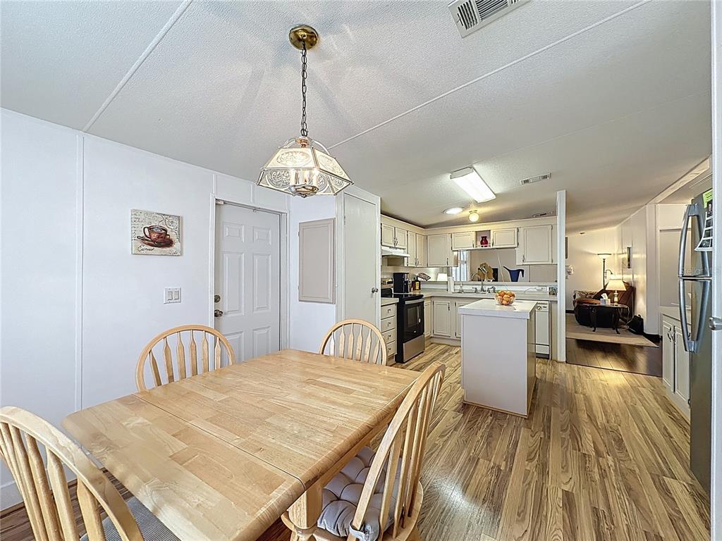 251 Patterson Road, Unit I3 Haines City, FL 33844 - Photo 9 of 38 a view of a dining room with furniture a chandelier and wooden floor