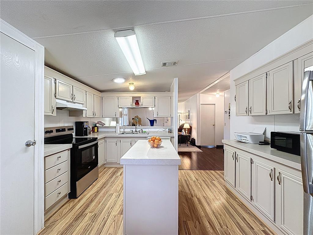 251 Patterson Road, Unit I3 Haines City, FL 33844 - Photo 10 of 38 a kitchen with stainless steel appliances a stove sink microwave and cabinets