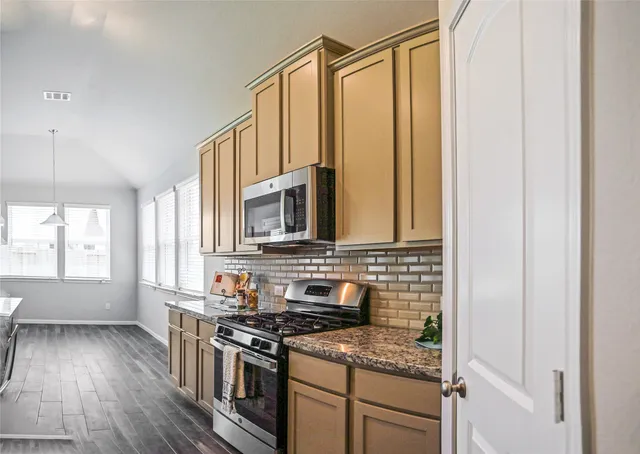 a kitchen with a refrigerator and white cabinets