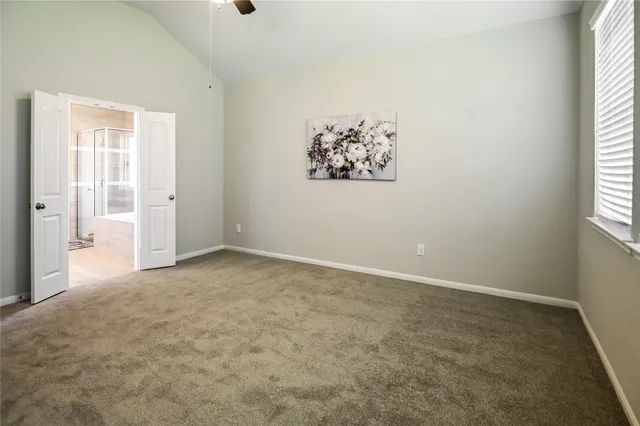 an empty room with a chandelier fan and closet