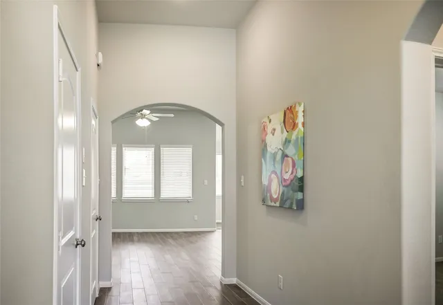 an empty room with wooden floor closet and windows