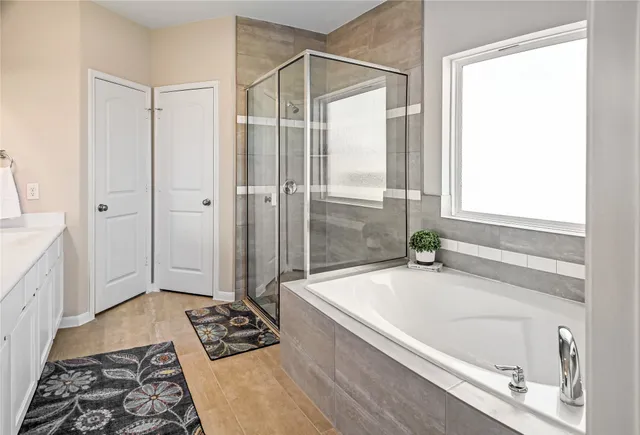 a bathroom with a tub a sink and a mirror