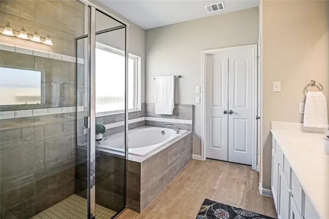 a spacious bathroom with a double vanity sink a mirror a and toilet