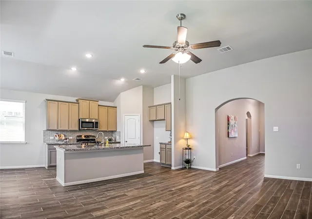 a kitchen with stainless steel appliances granite countertop a refrigerator and a stove top oven