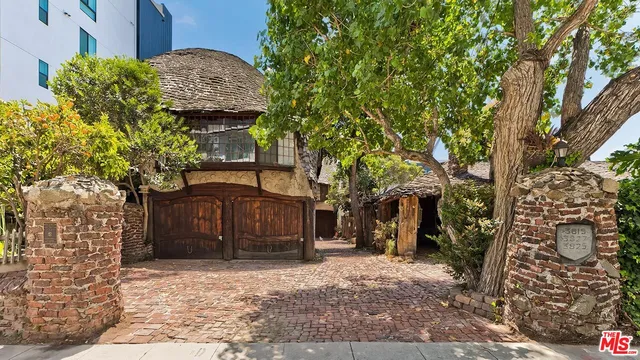 a front view of a house with a tree