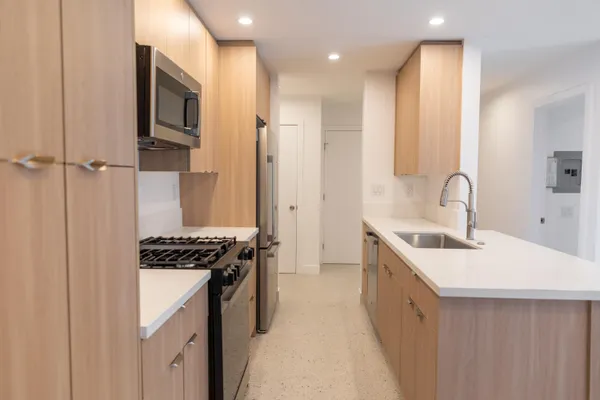 a kitchen with stainless steel appliances a sink stove and cabinets