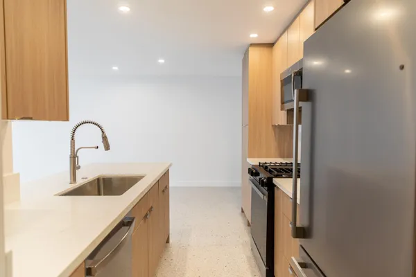 a kitchen with a sink a refrigerator and window