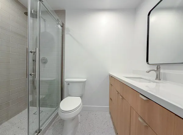 a bathroom with a granite countertop sink toilet and shower