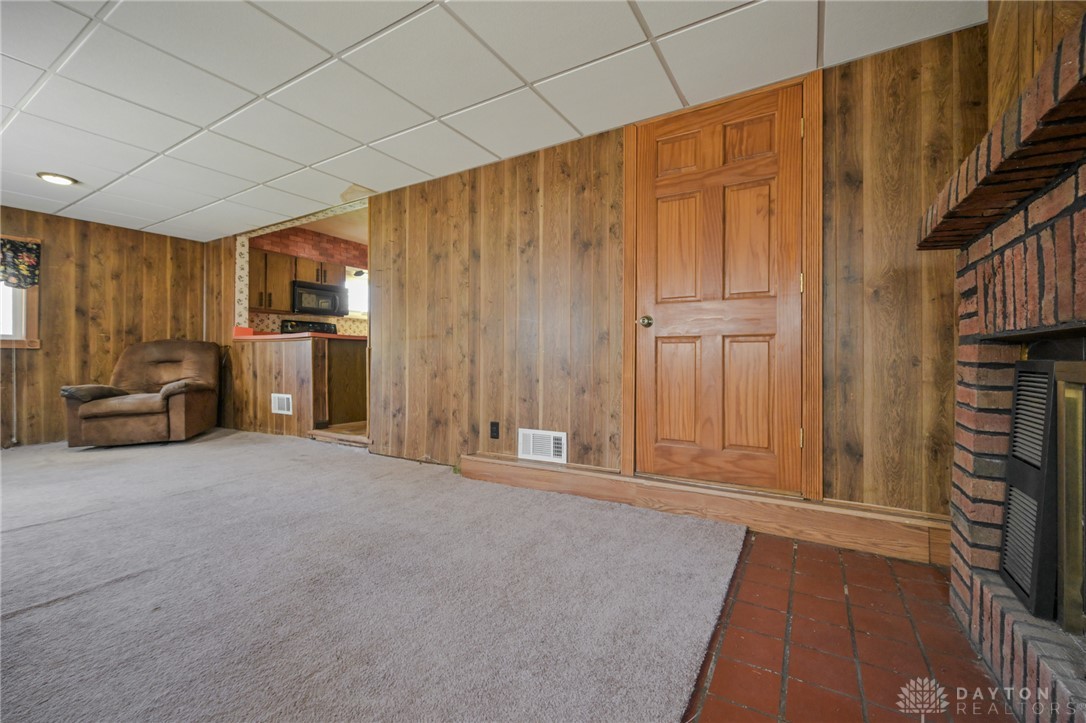 3057 Springfield Xenia Road Springfield, OH 45506 - Photo 27 of 37 This versatile living space features warm wood paneling and a cozy fireplace, creating an inviting atmosphere.